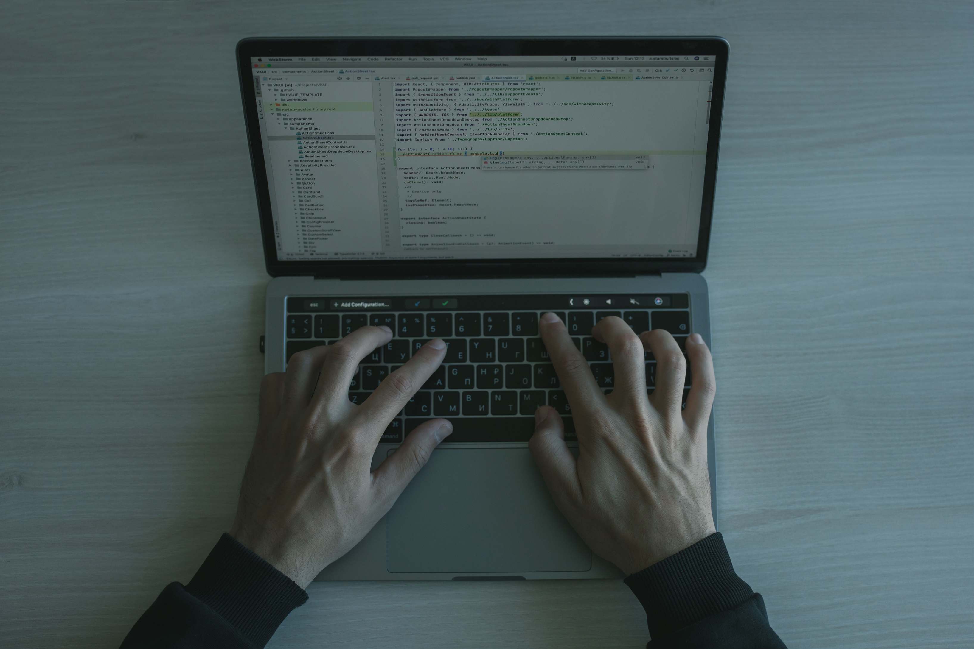 Hands typing on a laptop keyboard during software work